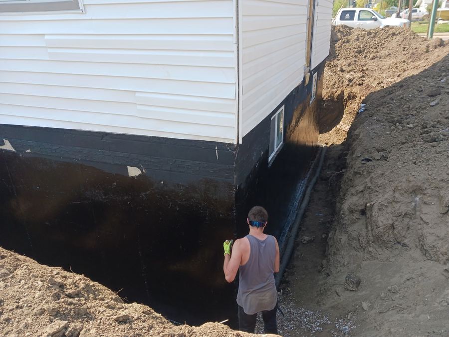 Excavation exposing foundation wall